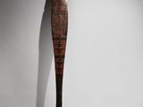 an old wooden spoon with a long handle on a white surface