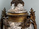 a large marble vase with a gold lid on a table
