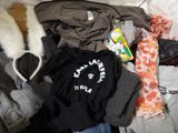 a pile of clothes that is sitting on a bed