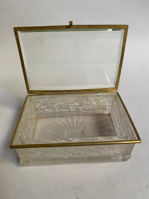 une image représentant une boîte en verre avec un couvercle, posée sur une surface blanche