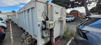des véhicules garés sur un parking à côté d'un utilitaire blanc