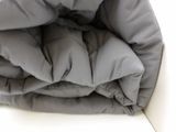 a close up view of a bed with a gray comforter