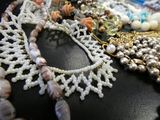 many different types of necklaces and bracelets on a table