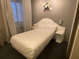 a white bed sitting in a bedroom next to a window