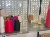 many different colored yarns on a shelf in a room