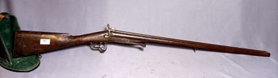an old gun with a wooden handle and a case on a white surface