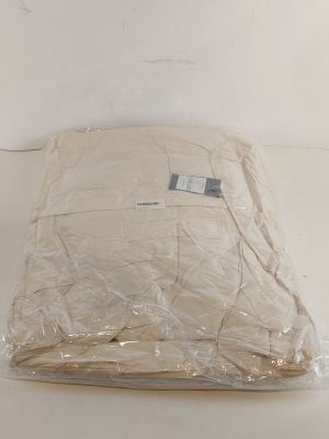 un oreiller blanc posé sur une table blanche, avec un sac en plastique