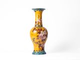 un vase jaune orné d'un motif floral