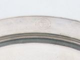 a close up of a silver plate with a monogram on it