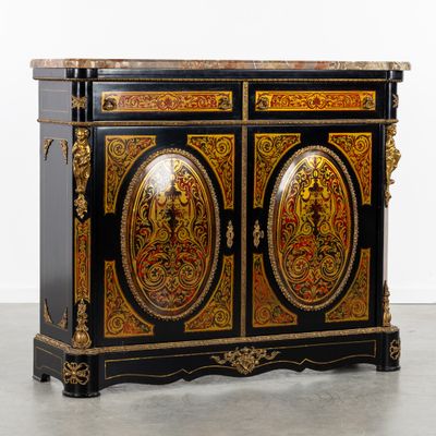 une armoire peinte en noir et or, à deux portes, avec un plateau en marbre