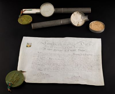 an old paper with a piece of paper next to it on a table