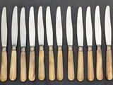 a set of six knives with wooden handles on a black surface