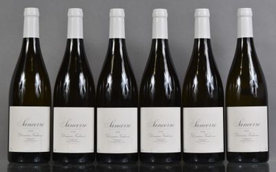 six bouteilles de vin sont alignées sur une table