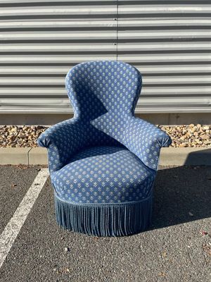 une chaise bleue posée au milieu d'un parking