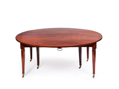 une table à manger ovale en acajou avec des pieds en laiton