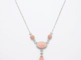 un collier avec une pierre rose et une chaîne en argent