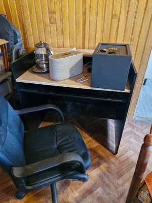 un bureau avec un ordinateur et une chaise dans la chambre