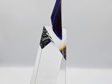 a glass sculpture of a sailboat on a white surface