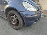 une petite voiture bleue garée au bord de la rue