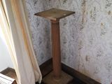 un socle en bois dans un coin de la pièce