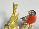 two figurines of birds sitting on top of each other