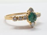 an image of a close up of a gold ring with a green stone