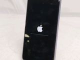a black iphone sitting on a stand on a white surface