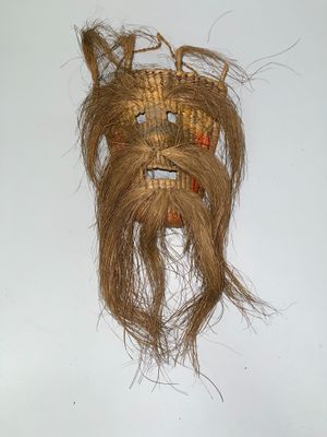 a picture of a wicker mask hanging on a wall