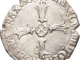 a close up of a silver coin with a cross on it