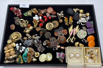une boîte noire remplie de bijoux divers posée sur une table
