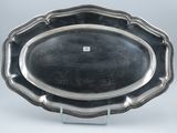 a silver plate with a scalloped edge on a stand