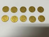a bunch of gold coins sitting on top of a white table
