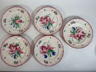four plates with flowers on them are sitting on a table