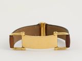 un gros plan d'une montre plaquée or montée sur un bracelet en cuir marron