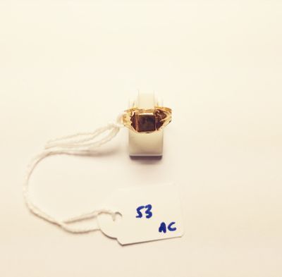 a gold ring with a white cord and a tag on it