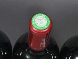 three bottles of wine in a wine holder on a table