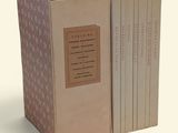three books in a cardboard box on a white surface