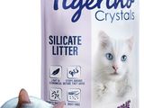 un chat blanc couché à côté d'un sac de litière pour chat
