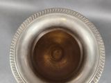 a silver vase with a brown center sitting on a table
