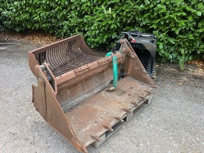 a bulldozer that is sitting on the ground next to some bushes