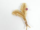 une image représentant une broche en or ornée d'une pierre rose au centre