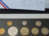 beaucoup de pièces posées sur une table à côté d'une feuille de papier