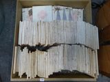 une boîte remplie de livres, sur laquelle est posée une chauve-souris