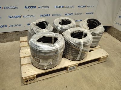 Plusieurs rouleaux de fils noirs et blancs sont posés sur une palette