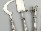 four pieces of silverware including a knife, fork, and spoon