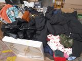 a box full of clothes and clothes sitting on the floor