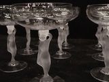 six clear glasses sitting on top of a black table