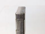 a silver lighter sitting on top of a white table