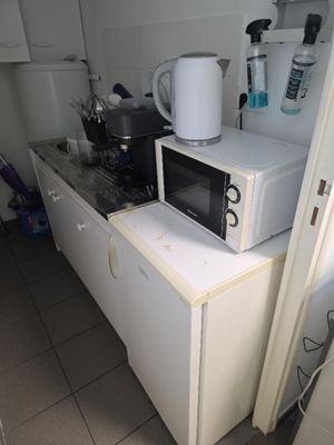 un micro-ondes blanc posé sur un meuble blanc