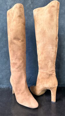 a close up of a pair of high heeled boots on a black surface